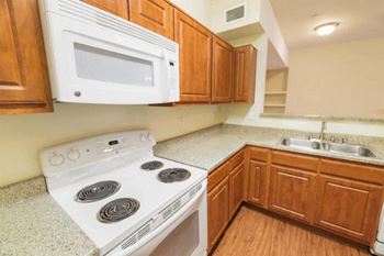 a kitchen with a stove top oven next to a sink